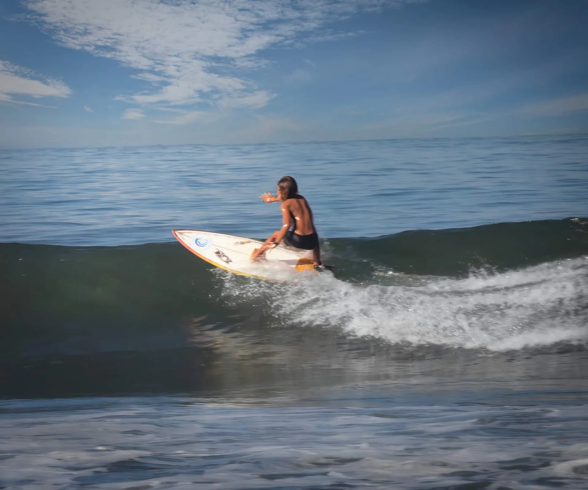 Surfer paddling out near Jacó Beach.